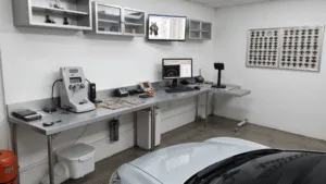 Fotorealistisch beeld van een moderne slotenmakerij gespecialiseerd in het programmeren van autosleutels, met een L-vormige roestvrijstalen werkbank vol gereedschap en diagnostische apparatuur, inclusief een OBD-II scanner en diverse lege autosleutels.